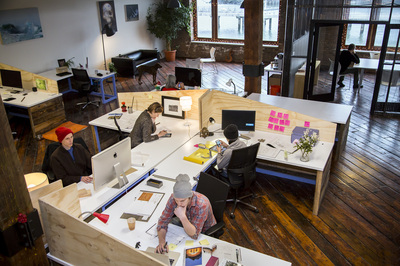 Modern coworking space with large desks and natural light at SHARED Brooklyn.